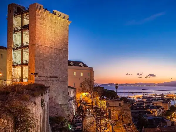 Torre medievale illuminata al tramonto, con vista sul porto e sul mare. Perfetto per scoprire cosa vedere a Cagliari in 3 giorni.